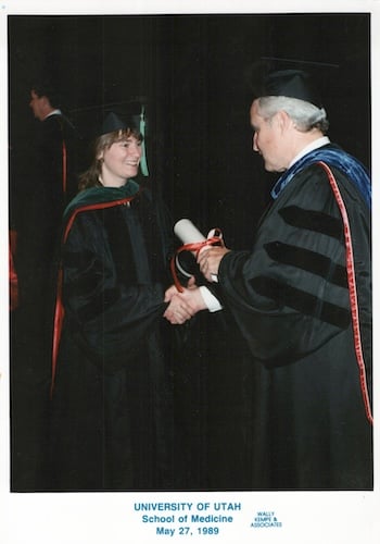 Chirstina Finlayson shaking hands with a man and receiving her diploma