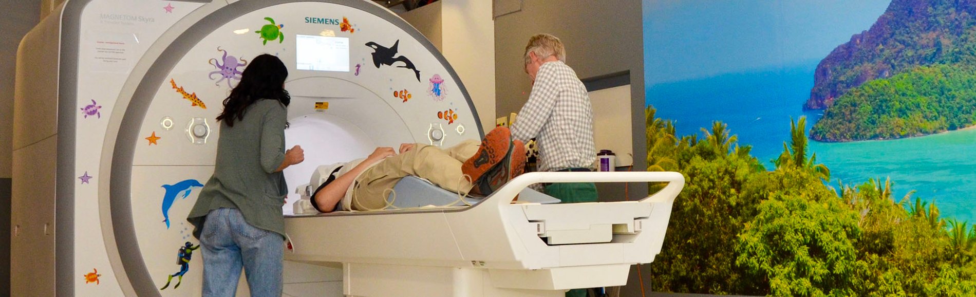 Researchers guiding patient into MRI scanner