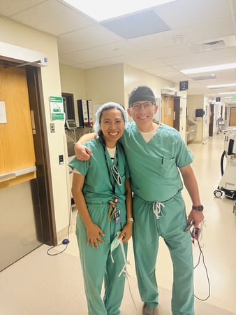Two doctors smile in their scrubs.