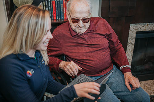 Female nurse with older man reviewing computer notes