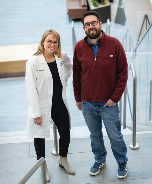 Whitney Jackson, MD, and Bobby Click smile while standing on a staircase.