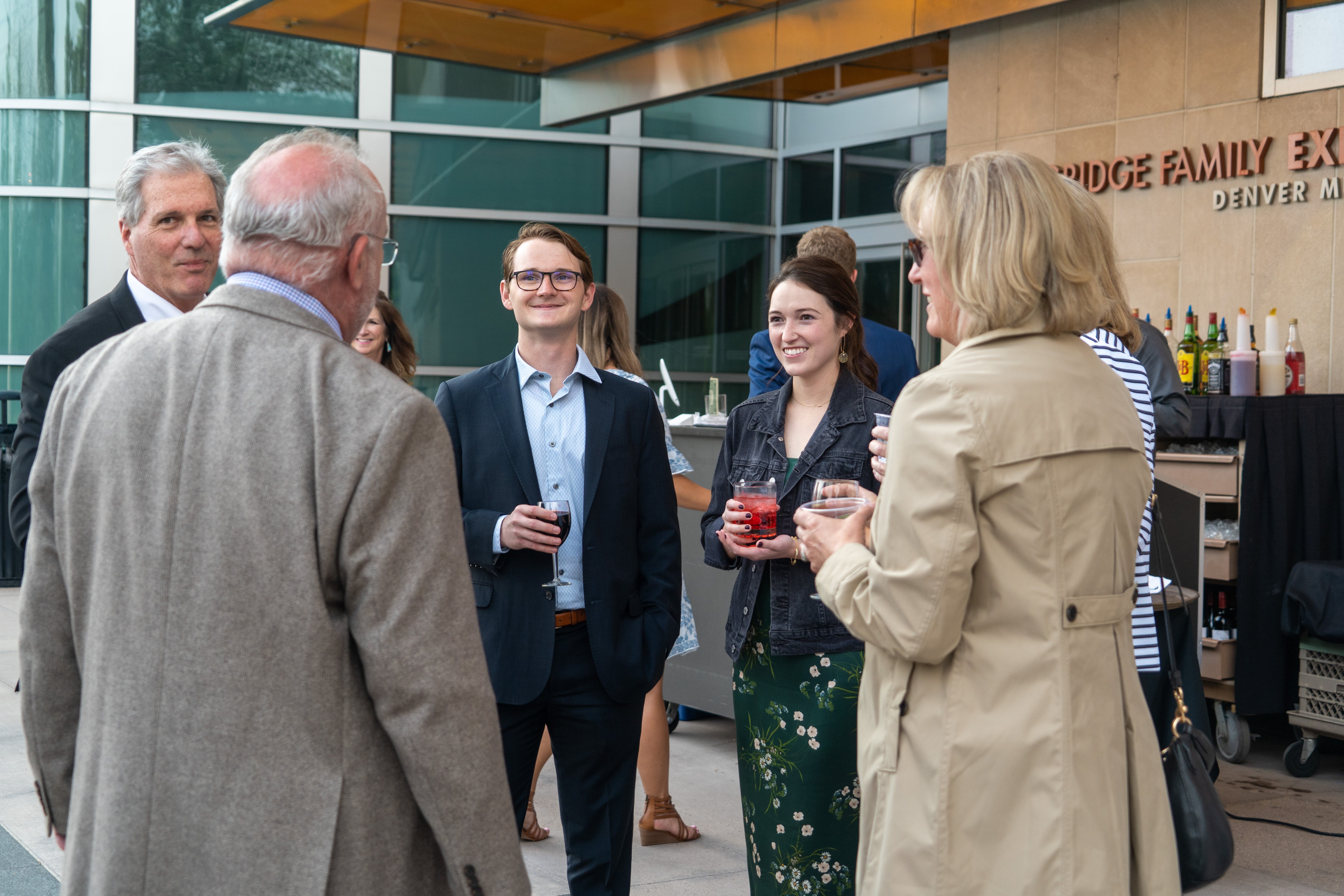 people standing outside in a circle socializing