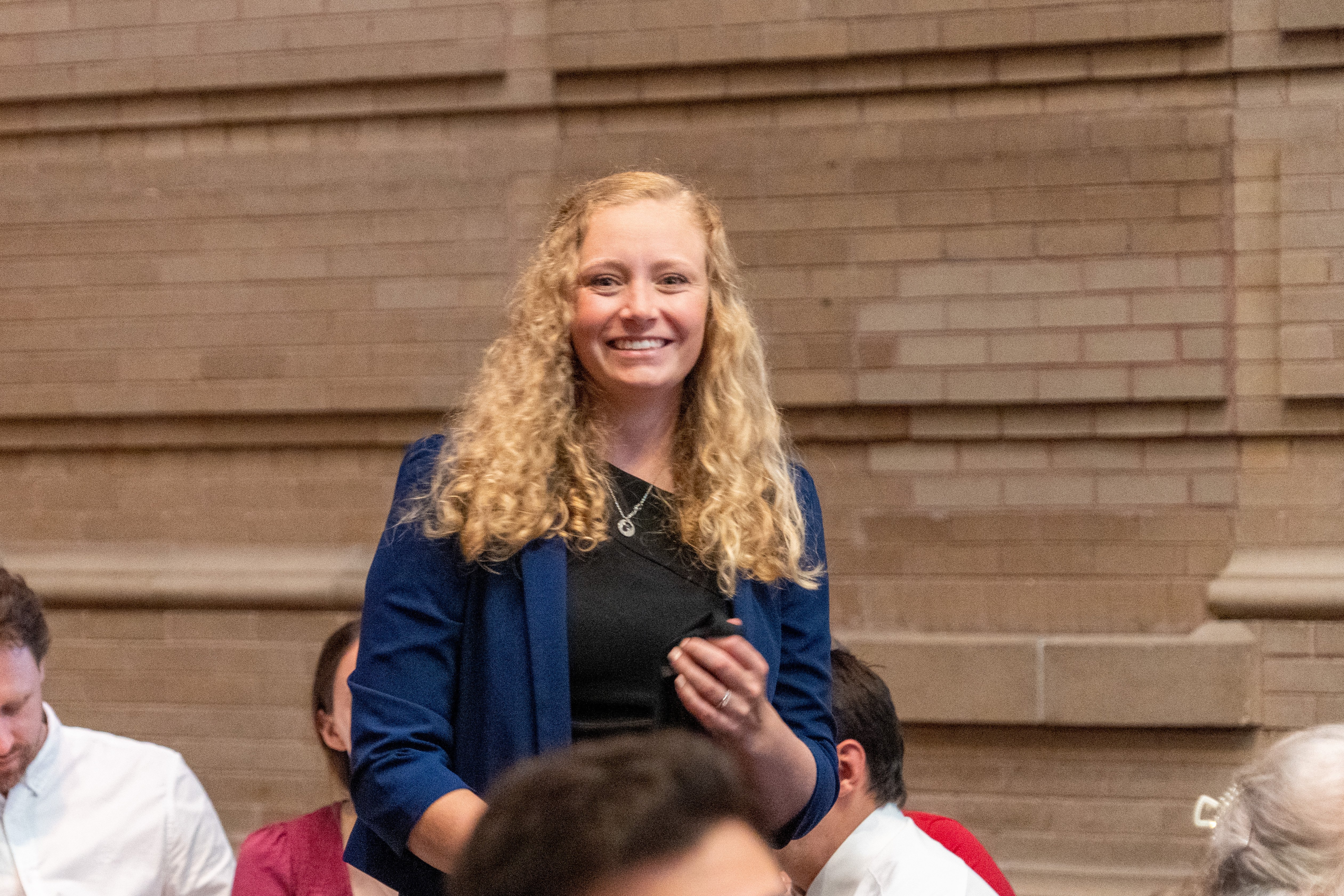 woman smiling, standing in a crowd