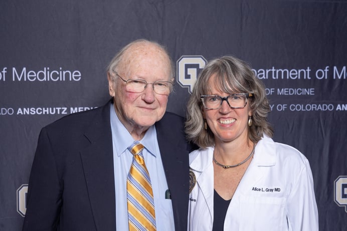 A man and a woman standing and smiling beside each other.