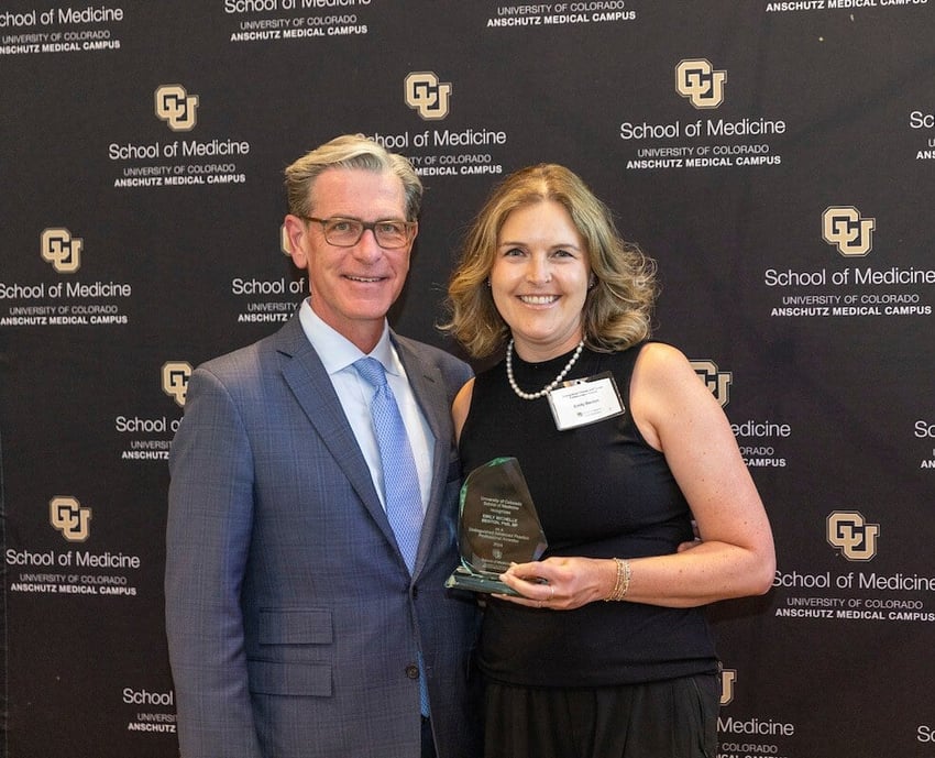 CU School of Medicine Dean John H. Sampson smiles alongside Emily Benton as Benton received a CU School of Medicine Distinguished Clinician Award.