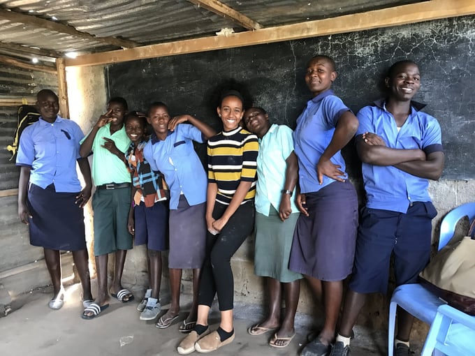 Feruth Kidane, center, smiles alongside students in Kenya.