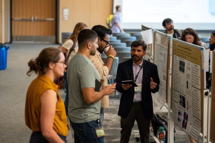 Poster session attendees and presenter