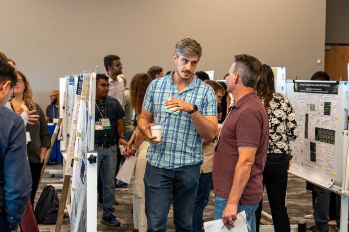 Poster presenter and attendees talking