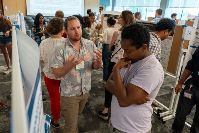 A poster presenter and attendee conversing