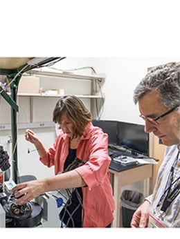 Emily Gibson and Diego Restrepo examined the miniature microscope they developed with two professors from CU Boulder. The team won a $2 million NIH Brain Initiative grant to refine and expand the use of the instrument.