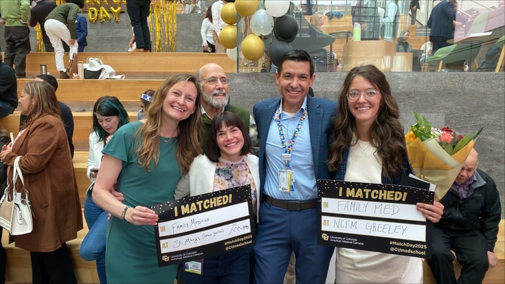 CU Anschutz medical students hold signs on their residency match announcements.