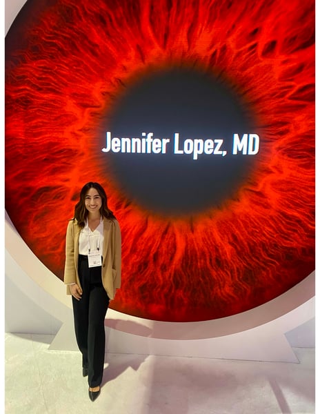 Jennifer Lopez, MD, stands in front of a display of an eye.