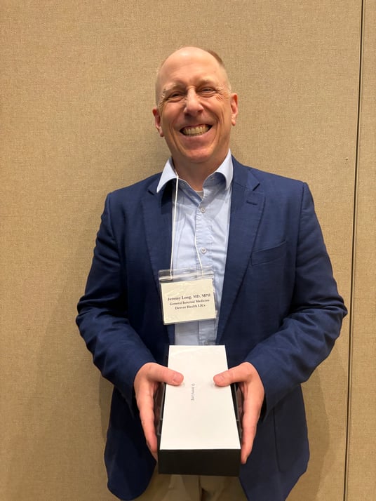 Image of Jeremy Long, MD, holding an award. 