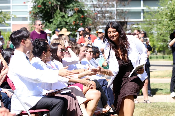 A first-year student gives high-fives to a row of other students in the Class of 2030.