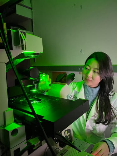 Mi-Hyun Nam, PhD, wearing her white coat while using ophthalmology equipment.