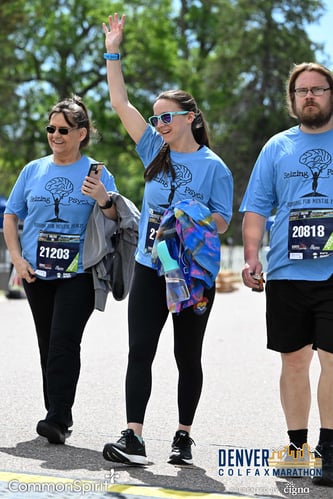 Three adults —&nbsp;two women and one man — all wearing glasses and blue shirts that read, "Seizing Psych," walk along the street on a sunny day.