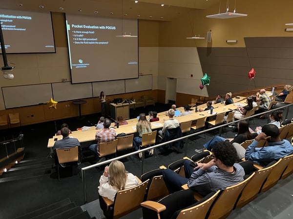 Trainees sit in a lecture hall to learn about POCUS.