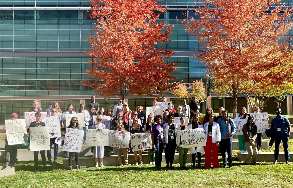 Community members hold up signs. 