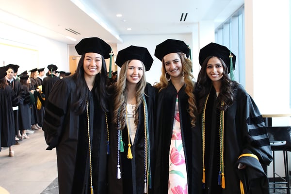 Four female graduates pose for a photo.
