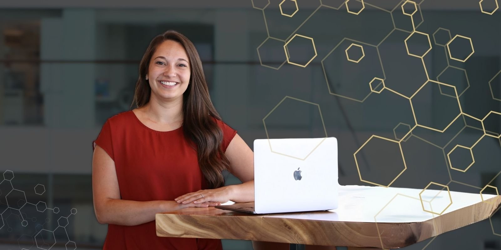 Jessica Clawson stands at a desk with her computer nearby. A gold hexagon pattern accompanies the photo.