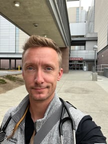 Selfie of Josiah Shaw in front of the entrance of an emergency department.