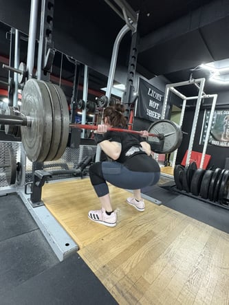 Med student Tessa Petersell performing a squat during her powerlifting training.