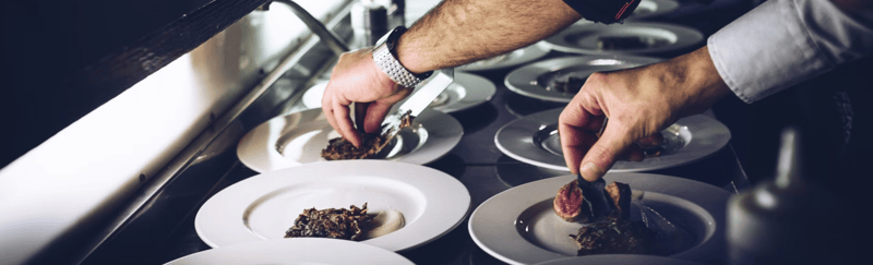 Image of a chef putting food on a plate.