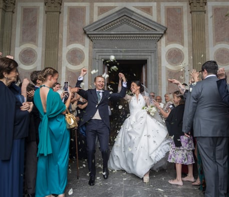 A wedding photo of Felan and Garcia, who are holding hands, surrounded by cheering friends and family.