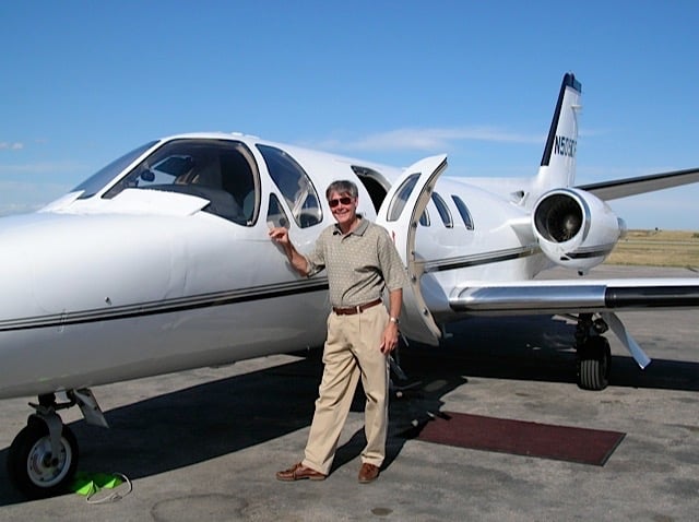 Geoff Slingsby, MD, standing outside of a small jet.