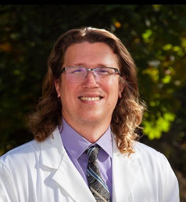 Travis Redd, MD, MPH, wearing a white coat.