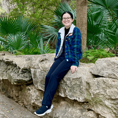 Uyen Dinh smiles while visiting a Botanical Garden