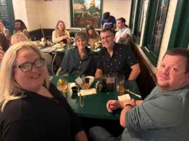 Group of palliative care education community members smiling at dinner