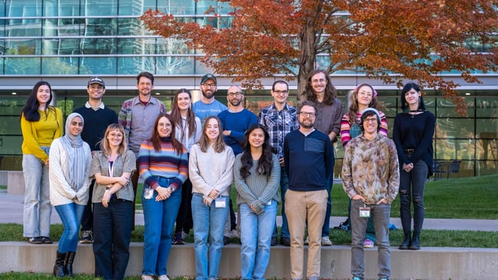 A group of researchers smile while standing outside on the CU Anschutz campus.