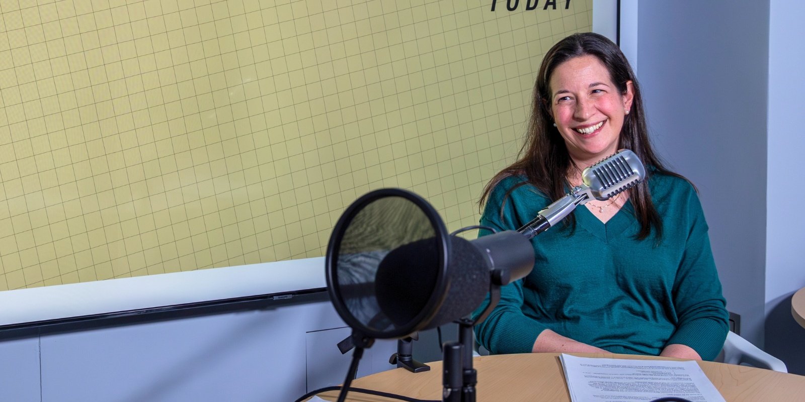 Karin Payne, PhD smiles in front of microphone