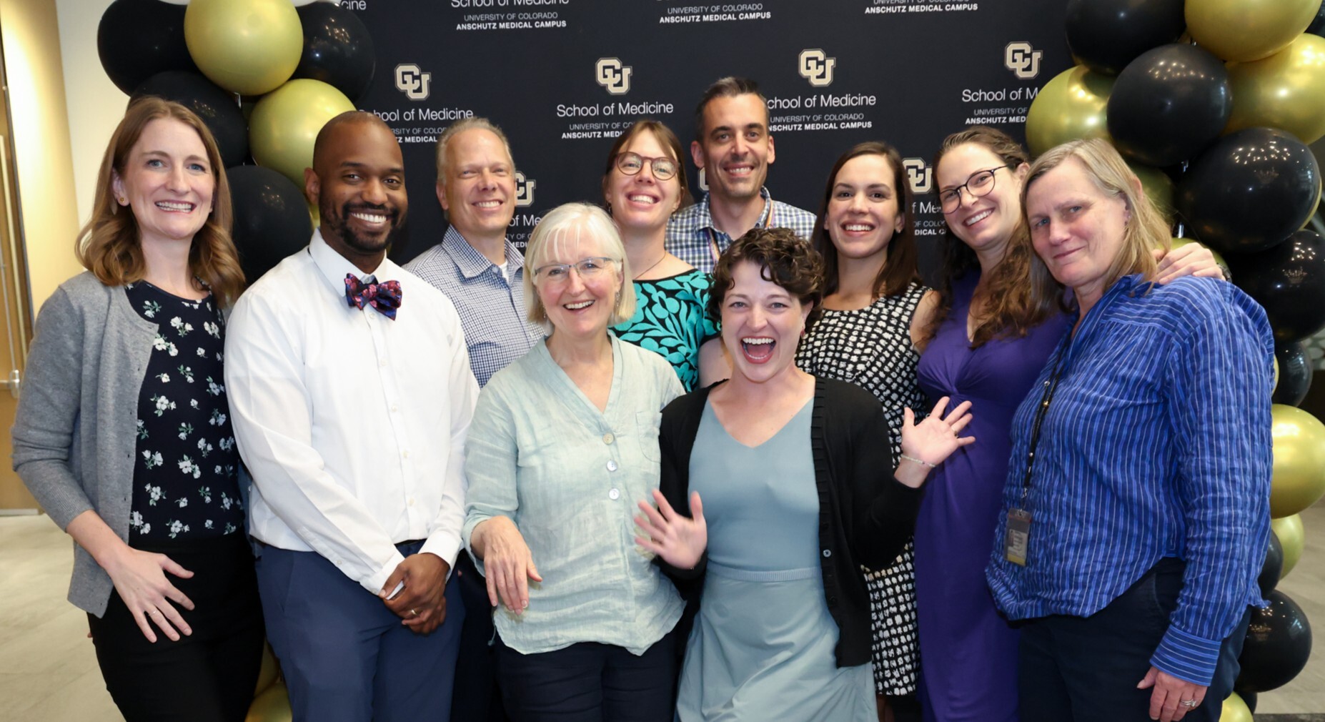 Group photo of DFM Faculty and Leaders in front of a CU Backdrop