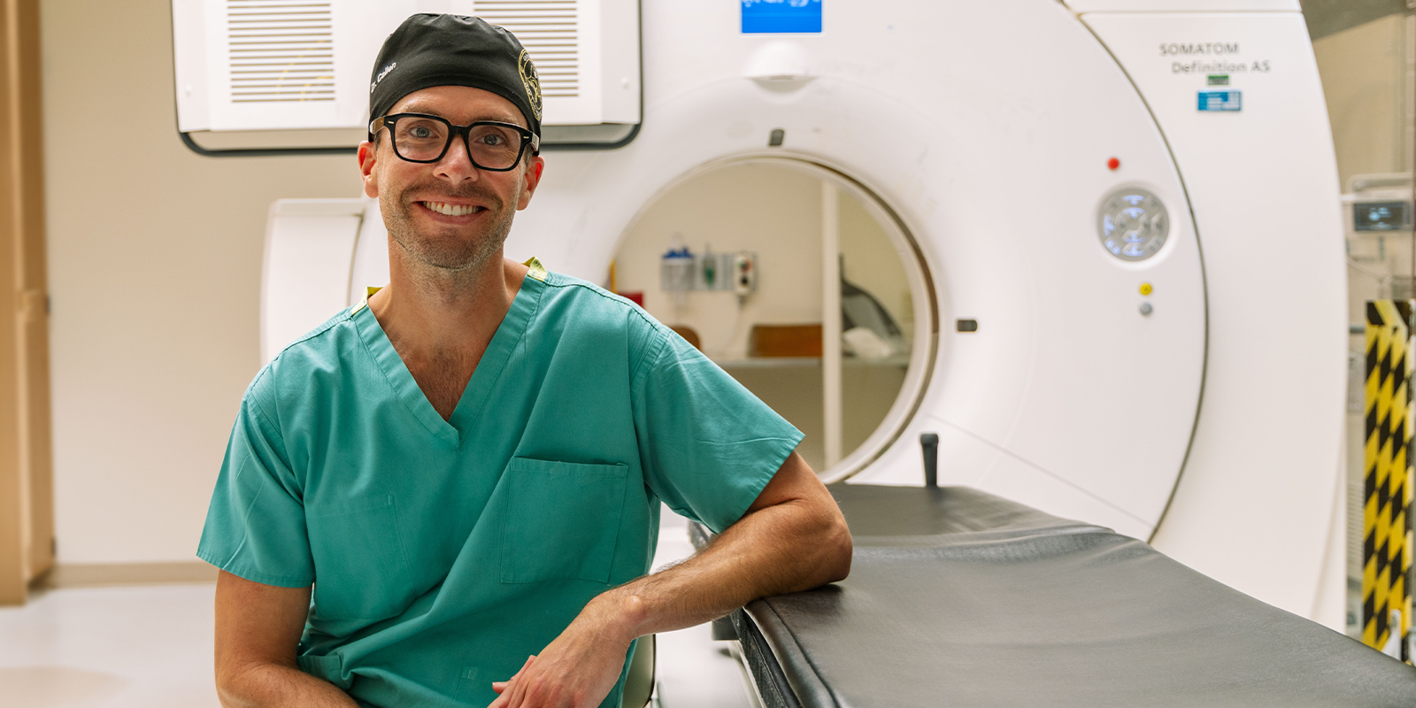Andrew Callen, MD, director of the CSF Leak Program at the University of Colorado Anschutz, sits next to the imaging equipment used in his clinic. 