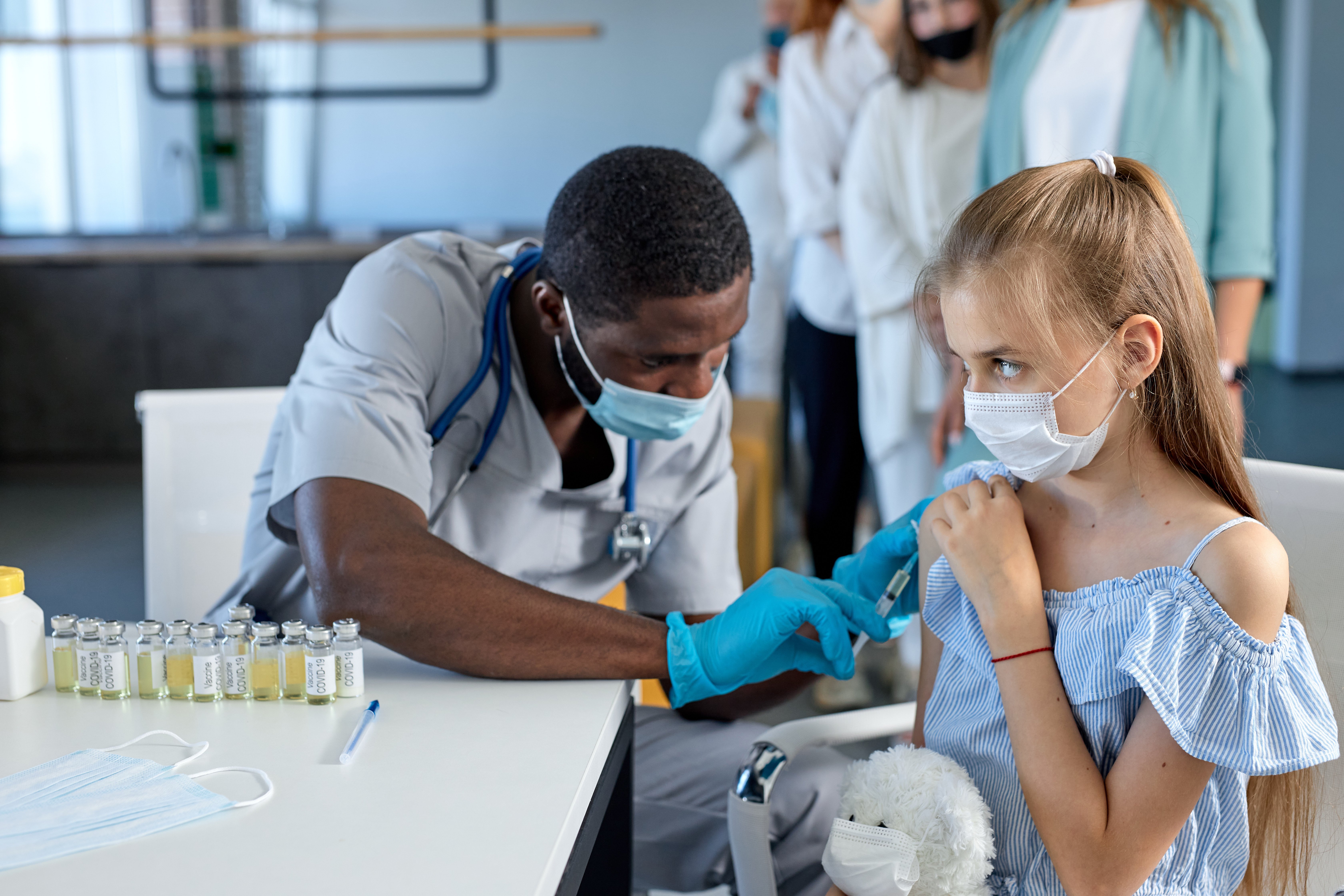 Doctor giving girl a vaccine. 