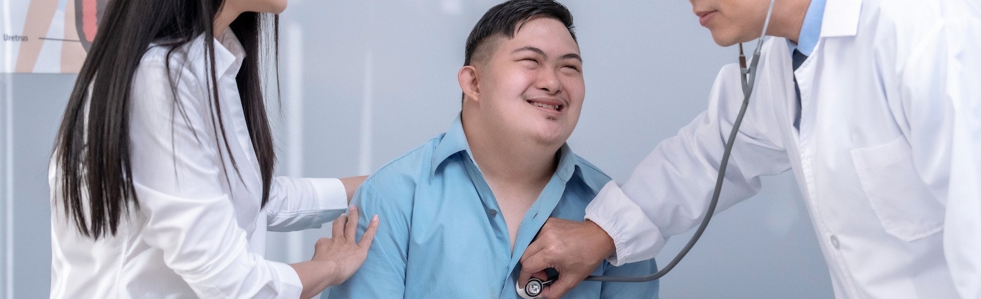 Man with Down syndrome with doctors listening to his heart with a stethoscope