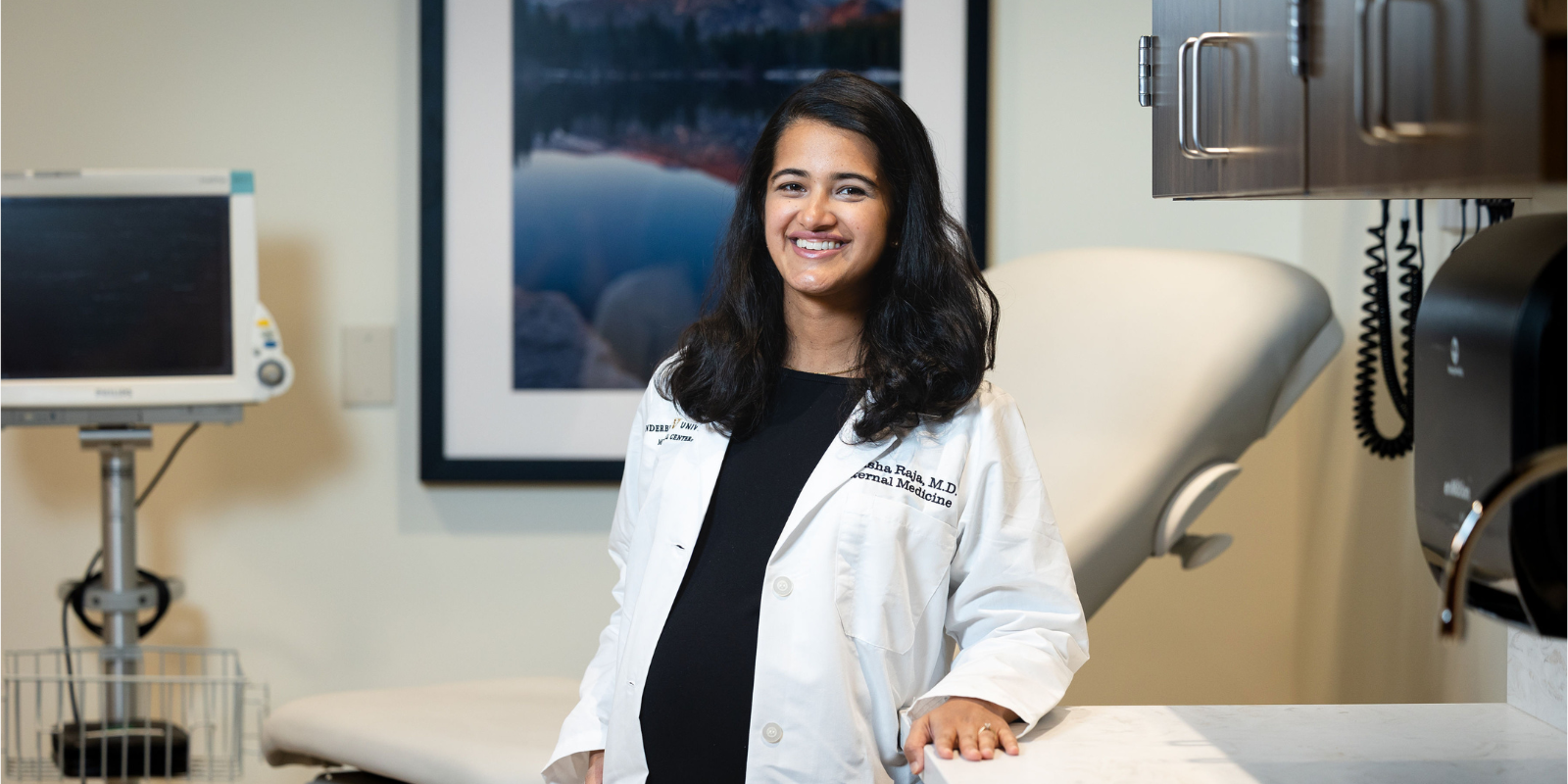 Anusha Raja poses for photo in medical office next to patient chair