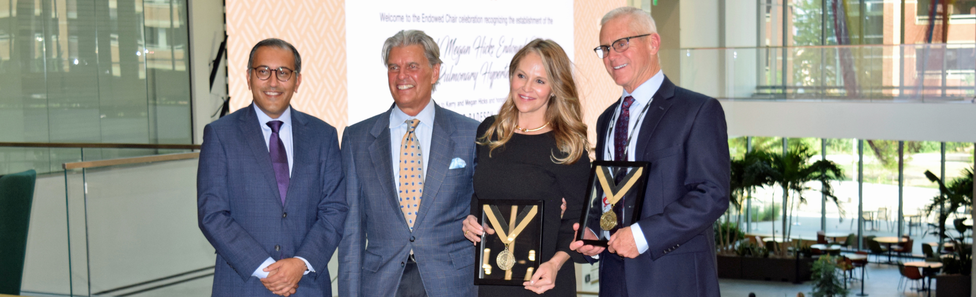 From left, CU Department of Medicine Chair Vineet Chopra, MD, MSc; Kerry and Megan Hicks; and David Badesch, MD, with medals recognizing the creation of the Kerry and Megan Hicks Endowed Chair in Pulmonary Hypertension, on Aug. 1, 2024, at the Anschutz Health Sciences Building.