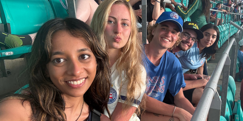 A selfie of a group of five students a row of stadium seats in Brazil
