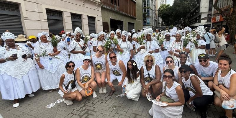 A group of students on the street with local wearing white dresses at Festa da Lavagem do Bonfim
