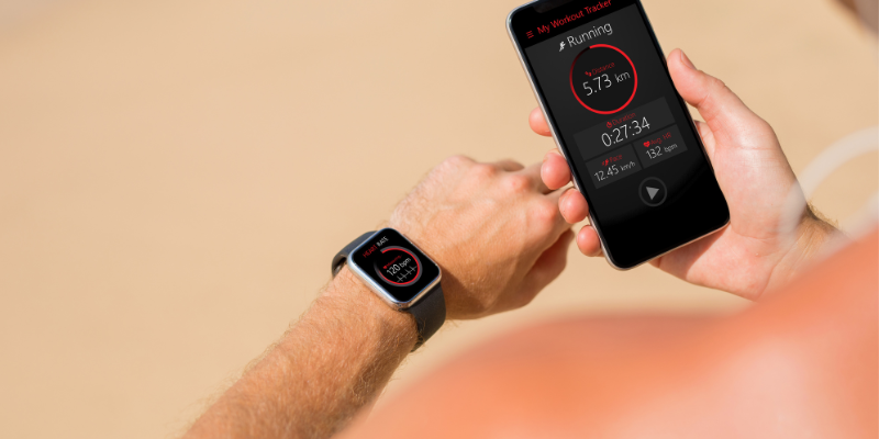 A runner uses his watch and phone to track his health data.
