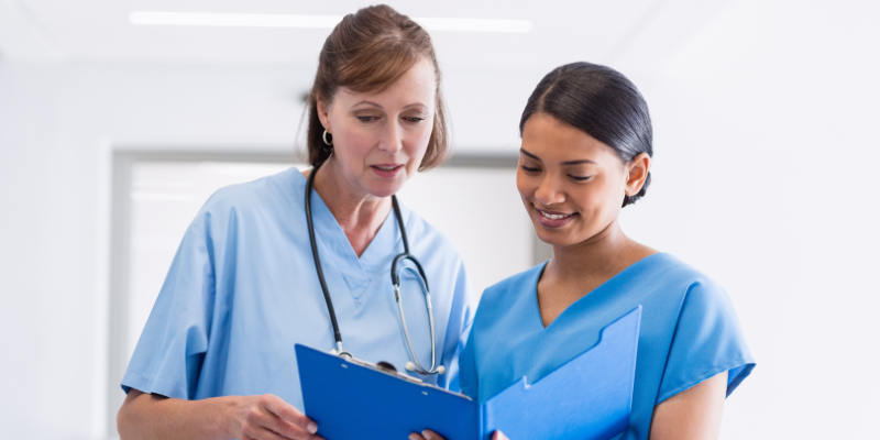 two nurse practitioners looking at a clipboard