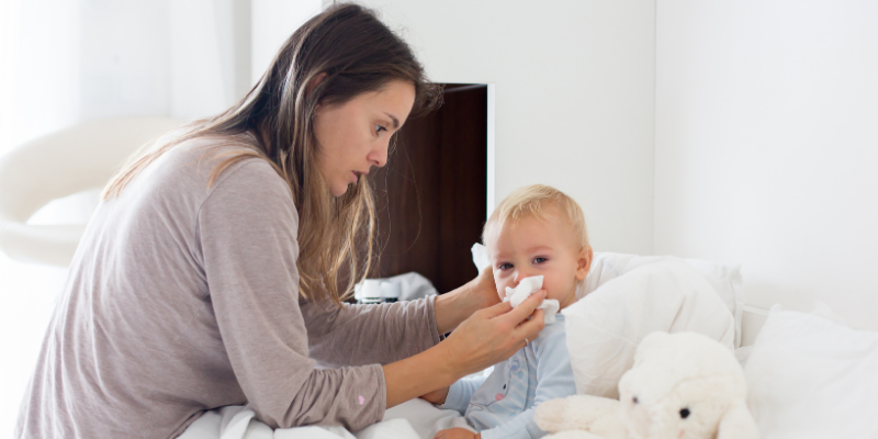 mother with child blowing his or her nose