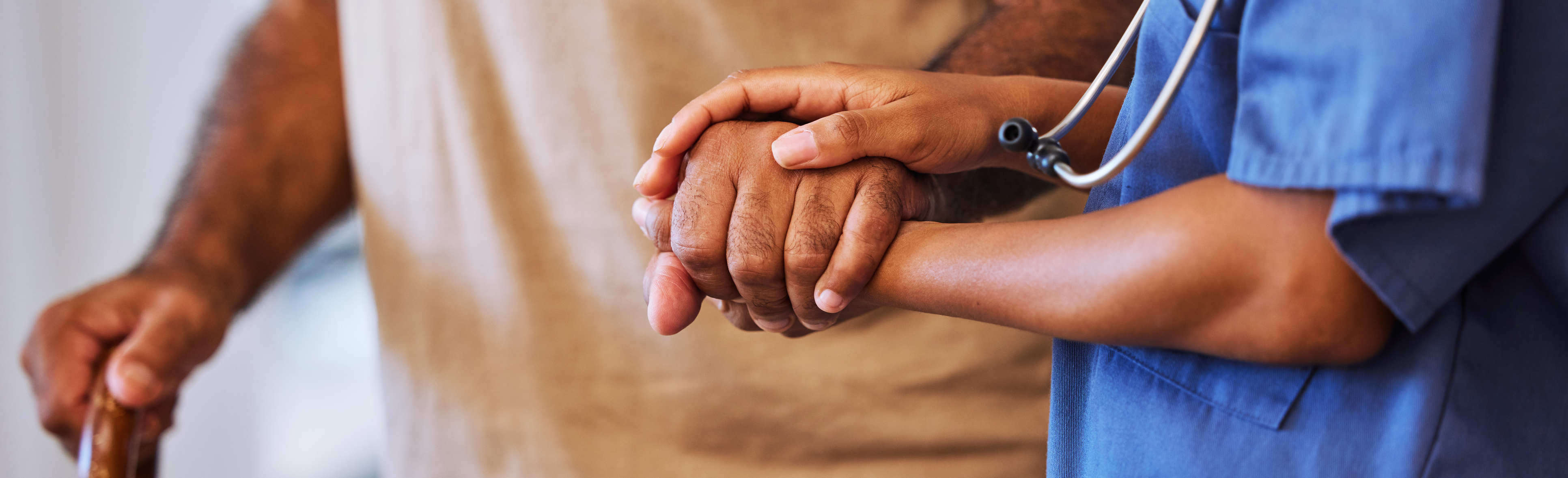 Health care professional holding hands with man