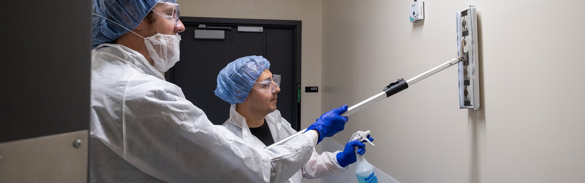 Two workers cleaning a biomanufacturing facility