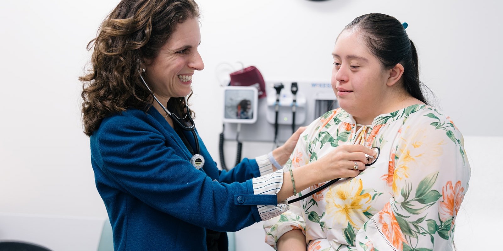Physician listening to a woman with Down syndrome's heart with a stethoscope. 