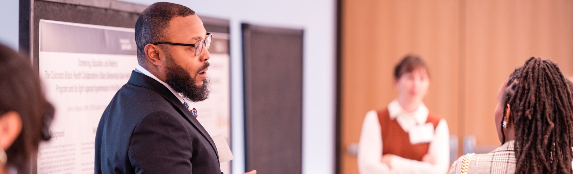 Johnny Williams presenting research in front of poster