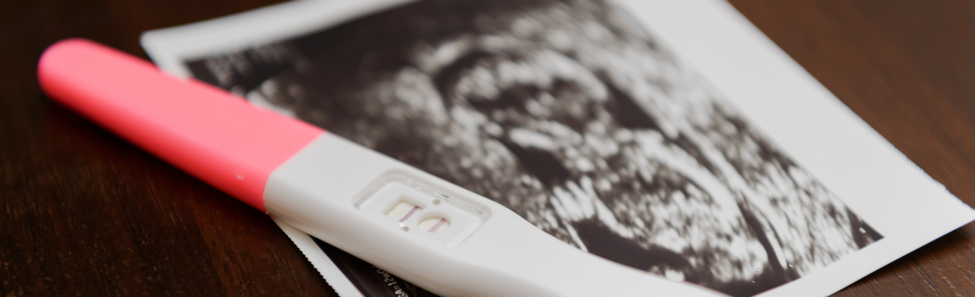 A photo of a pregnancy test and ultrasound image